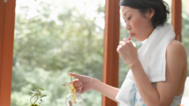 Mulher escovando os dentes com pasta de dente natural