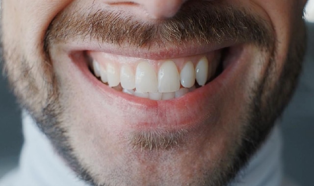 Mulher usando tira para branquear os dentes
