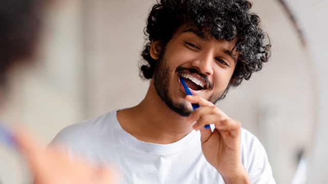 Menino escovando os dentes para prevenção oral 