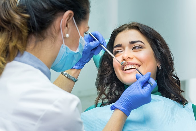 Dentista examinando boca de paciente no consultório