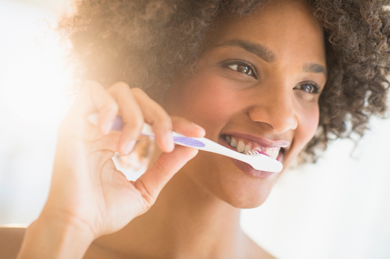 Retrato de uma mulher escovando os dentes