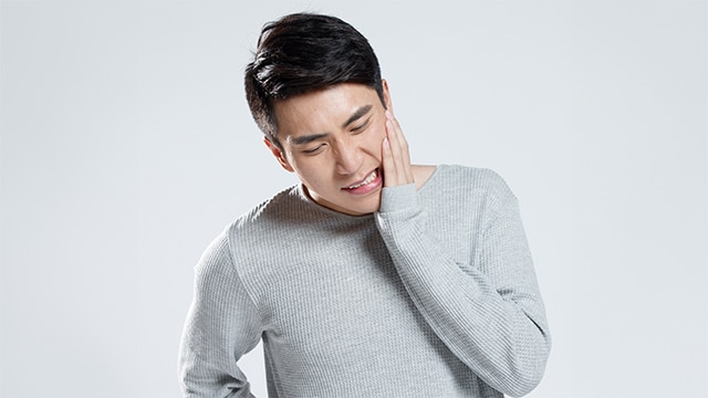 Mulher com gosto ruim na boca abraçando um homem enquanto sorri, e mais quatro familiares também estão felizes sorrindo 