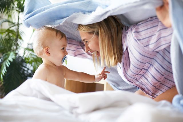 bebê com chupeta ortodôntica e sua mãe brincando