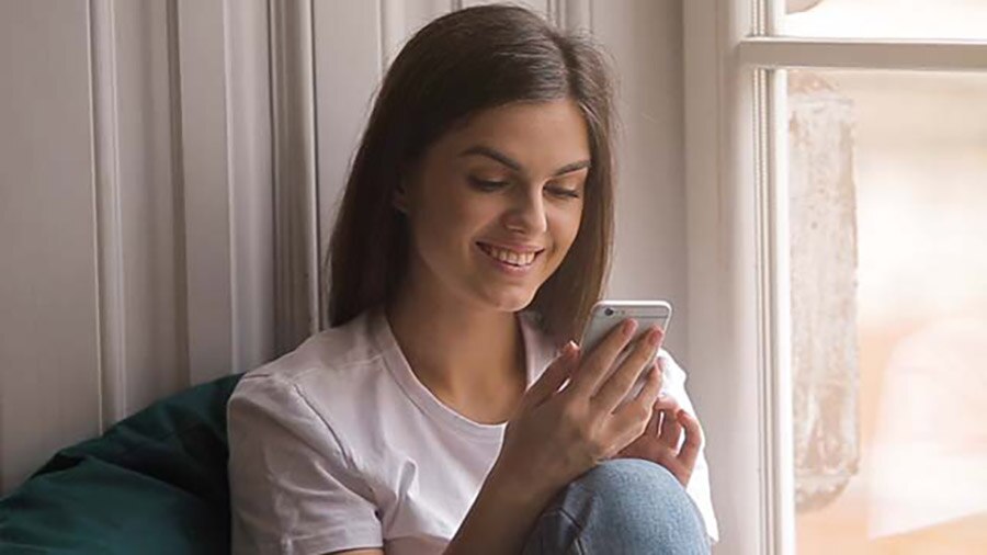 Mulher olhando o celular, usando inovações tecnológicas
