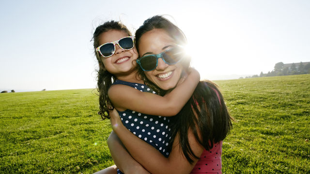 Mãe e filha usando óculos de sol em um dia ensolarado.