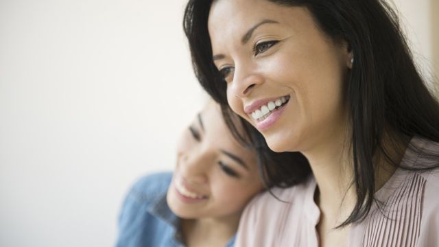 Mãe e filha sorrindo e abraçadas