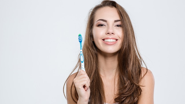 Menina se perguntando se a escova de dente elétrica é melhor do que comum