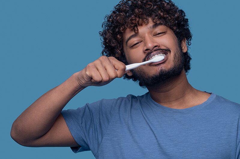 Homem escovando os dentes com uma pasta de dente sem menta