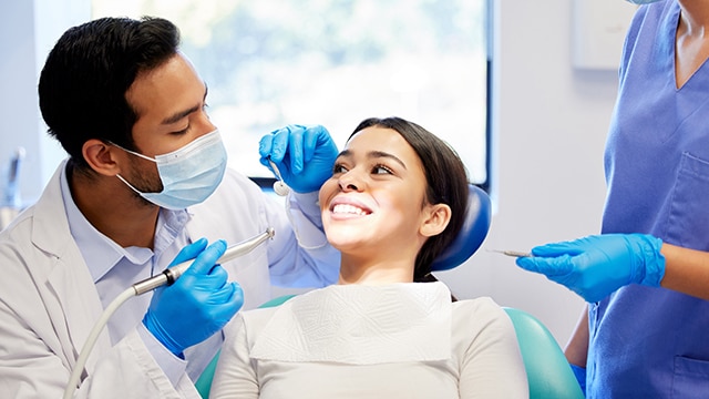 Mulher cuidando da sua saúde oral escovando os dentes.