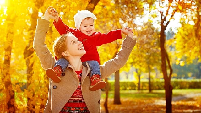 Uma mulher é sua criança sorrindo no parque
