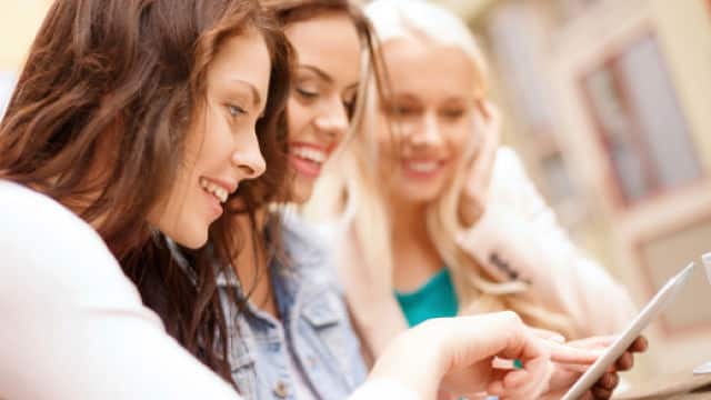 mulheres sorrindo e interagindo com sua tablet