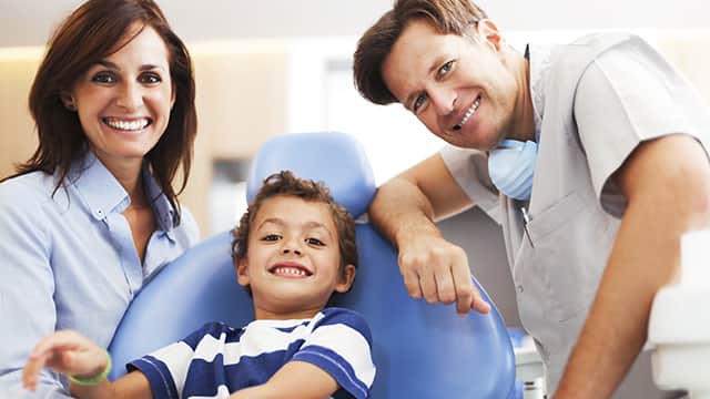 Mãe e filho visitando o dentista para crianças