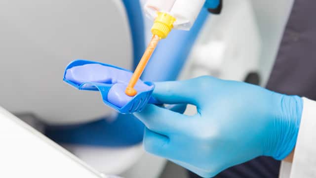 Um dentista está preparando um kit de moldagem dentária