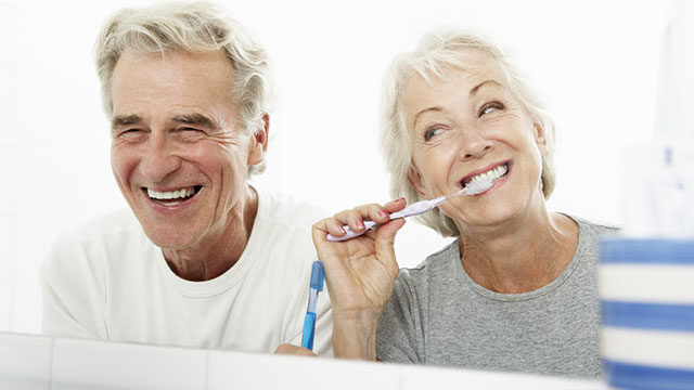 Casal de idosos no banheiro escovando os dentes