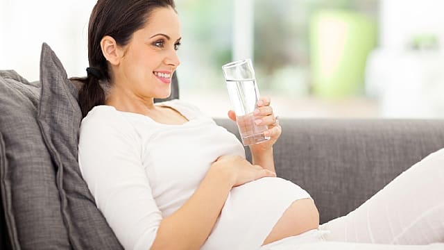 Mulher grávida bebendo água