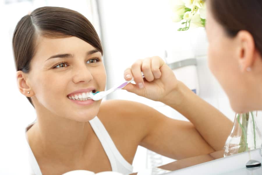 mulher escovando os dentes