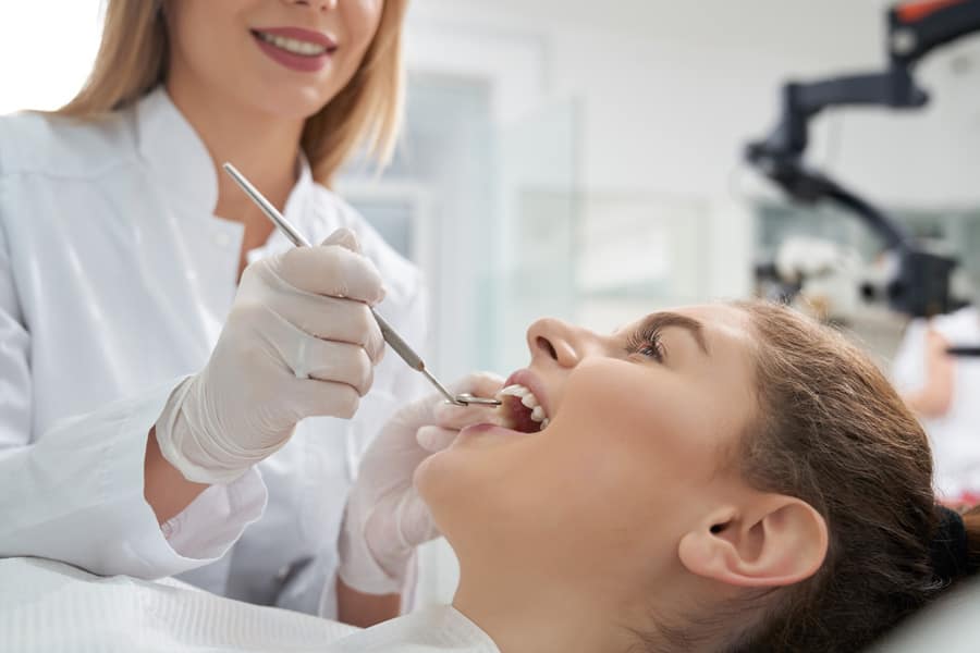 Médico dentista que trata os dentes de uma mulher na clínica odontológica