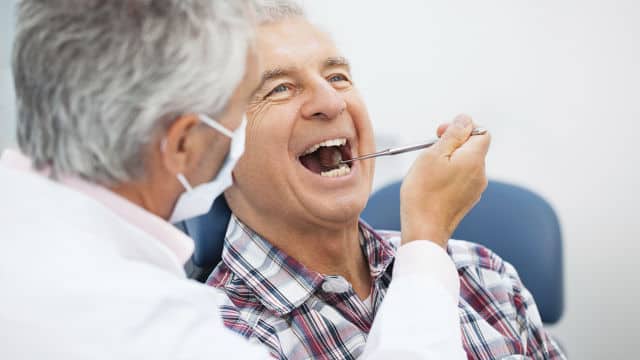 Dentista trabalhando nos dentes do seu paciente