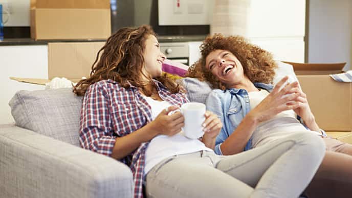 Mulheres sorrindo sentadas em um sofá, felizes com o resultado da limpeza de dente