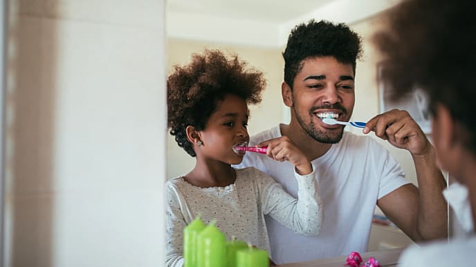 Pai e filho escovando os dentes
