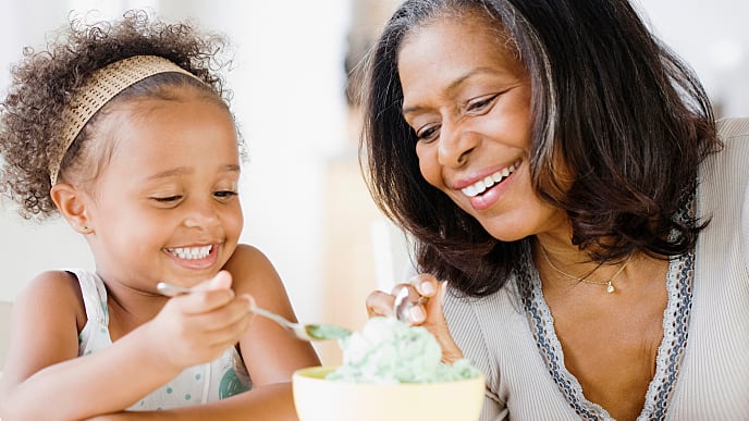 Mãe e filha sorrindo e compartilhando juntas um gelato